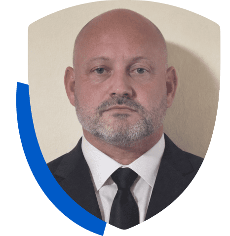 Man in suit within shield-shaped frame.